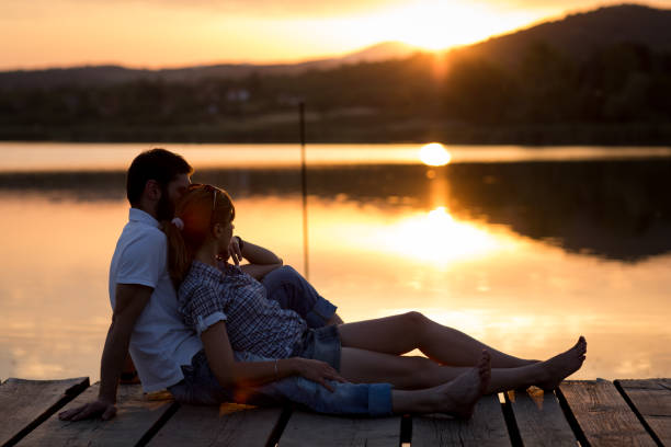 istock Couple enjoying sunset at lake pier 863750300