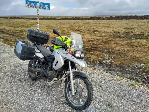 Nordkapp, Norway - July 07, 2017: Bmw touring motorcycle parked in front of the road sign of Nordkapp, Point of view from the motorcycle.
