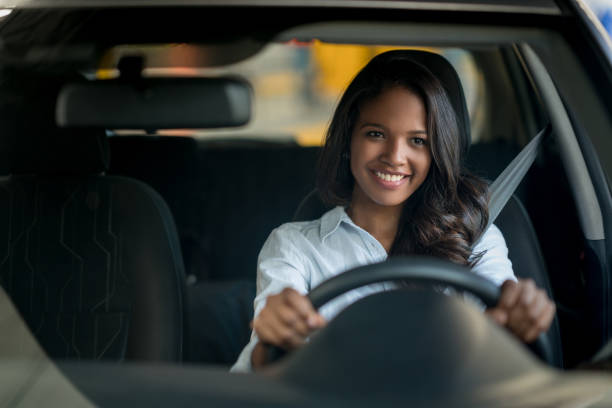 felice donna afroamericana alla guida di un'auto - car african descent shopping car dealership foto e immagini stock