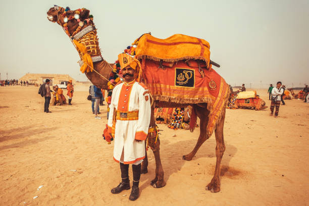 砂漠の風景とラジャスタン州の砂漠のフェスティバル中にラクダとインドの役員 - camel fair ストックフォトと画像