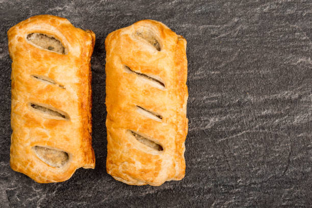 Sausage Rolls in Pastry Sausage Rolls in Pastry On A Black Slate Kitchen Tile With Copy Space sausage roll stock pictures, royalty-free photos & images