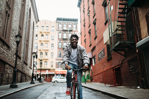 A young African American man explores China Town in New York City with his fixed gear bicycle.