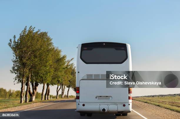 White Intercity Bus Is Driving Along The Road Stock Photo - Download Image Now - Bus, Rear View, Coach Bus