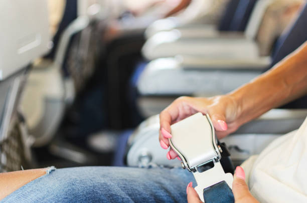 istock Woman hands fasten belts in airplane 863839516