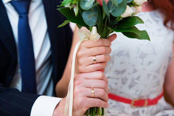 istock Bride and groom hands with wedding rings 863839860