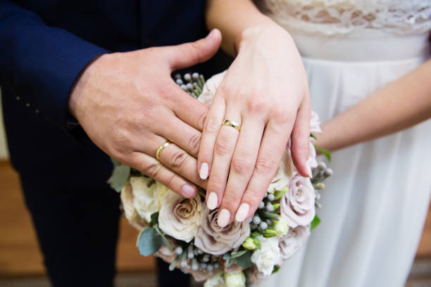 istock Bride and groom hands with wedding rings 863842230