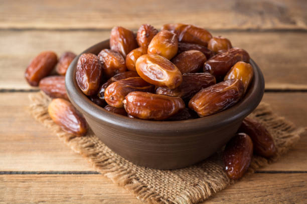 istock Dried dates fruit in ceramic bowl on wooden table. 863842926