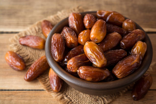 istock Dried dates fruit in ceramic bowl on wooden table. 863842970