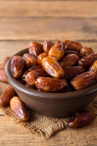 istock Dried dates fruit in ceramic bowl on wooden table. 863843070