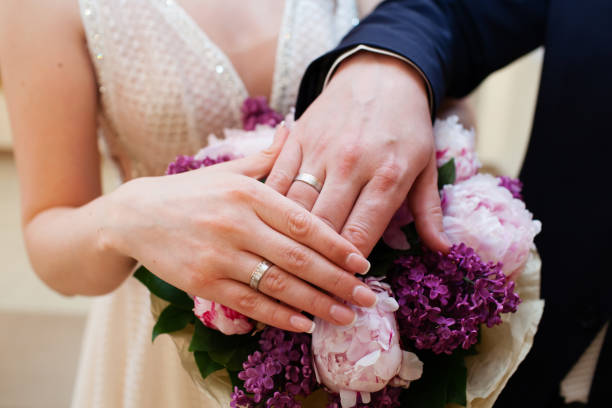 istock Bride and groom hands with wedding rings 863846030