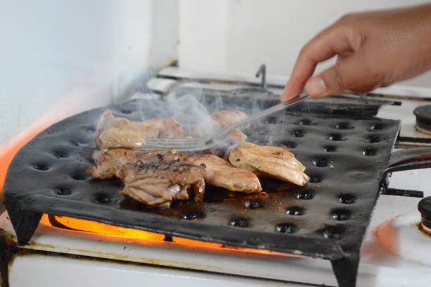 Grilled chicken on a barbecue grill on a gas fire