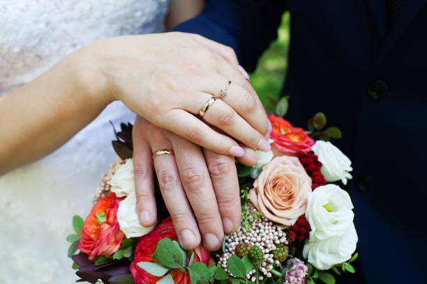istock Bride and groom hands with wedding rings 863857116