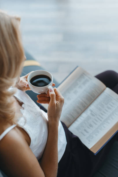 istock woman reading book and drinking coffee 863861064