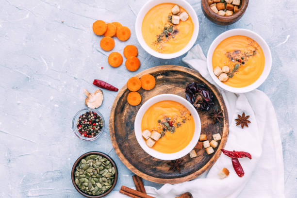 istock Three bowl with carrot soup and spices. Flat lay, top view 863861474