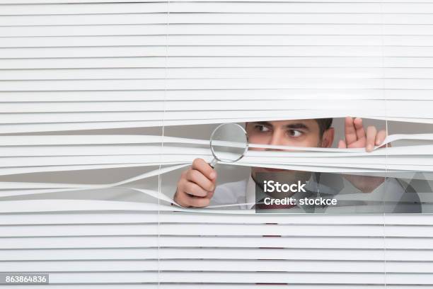 Man Watching Through Window Blinds Stock Photo - Download Image Now - Looking Through An Object, Looking Through Window, Window Blinds