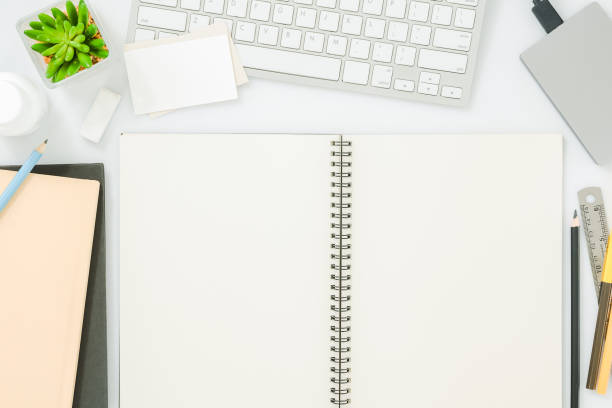 istock Blank notebook page on modern white office desk table with supplies for mockup. Top view, flat lay 863886832