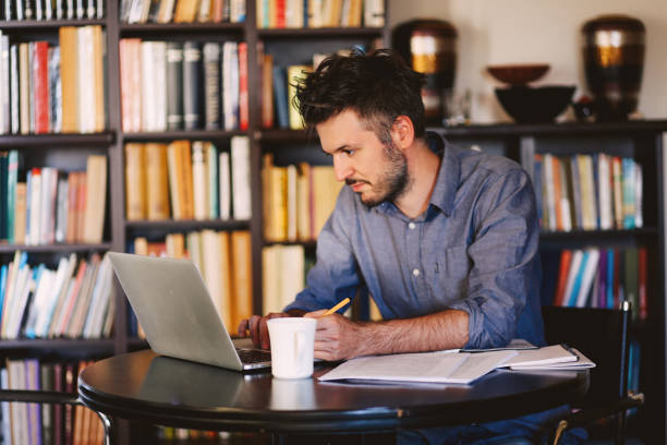 istock Young man reading and working at home 863887060