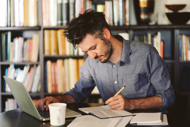 istock Young man reading and working at home 863889198