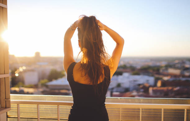 istock Young woman enjoying the balcony view 863890326