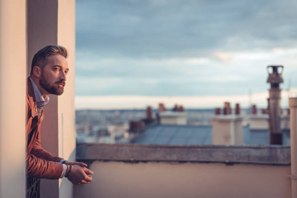 istock Bearded man looking out over the city at sunrise 863898452