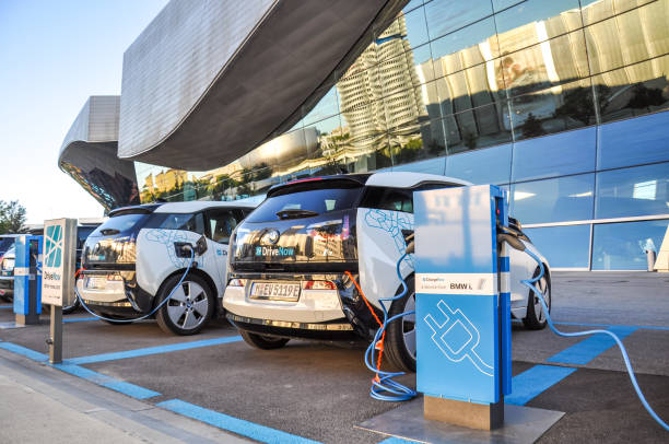 Two 'DriveNow' BMW i3 electric cars being charged at a charging station at 'BMW Welt' near BMW headquarters. 'DriveNow' is a car sharing company owned by BMW. stock photo