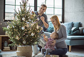 Happy family decorating tree