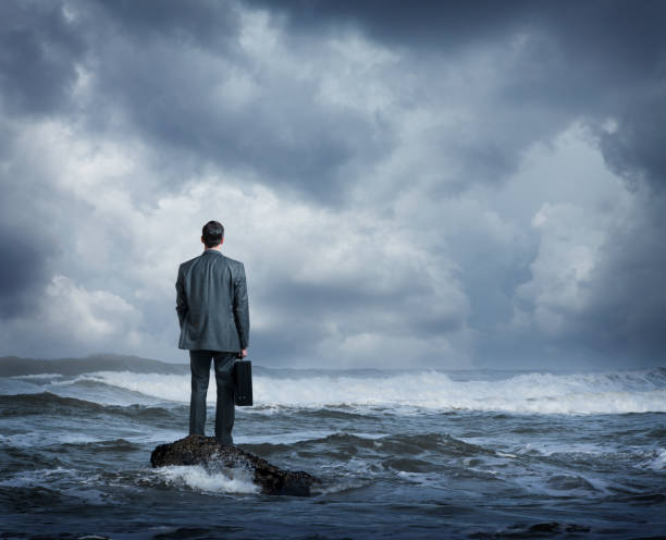 istock Businessman Standing In Rough Ocean Surf 863925080