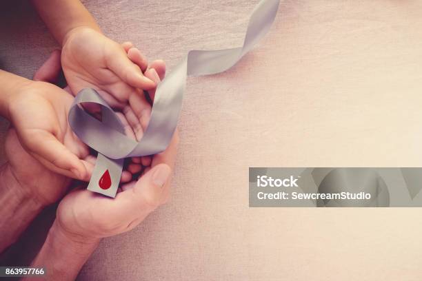 Adult And Child Hands Holding Grey Ribbon World Diabetes Day Stock Photo - Download Image Now