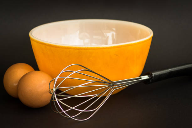 eggs, whisk and bowl - cake making mixing eggs imagens e fotografias de stock