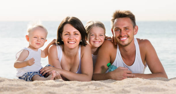 istock couple with two children lying on beach 863963596