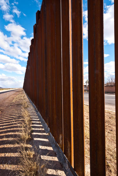 Shadows Cast Across the USA - Mexico Border The USA-Mexico Border Fence separates people in Douglas, Arizona, USA from their neighbors and family in Agua Prieta, Sonora, Mexico. jeff goulden sonoran desert stock pictures, royalty-free photos & images