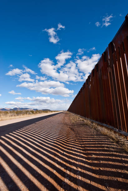 Shadows Cast Across the USA - Mexico Border The USA-Mexico Border Fence separates people in Douglas, Arizona, USA from their neighbors and family in Agua Prieta, Sonora, Mexico. jeff goulden border security stock pictures, royalty-free photos & images