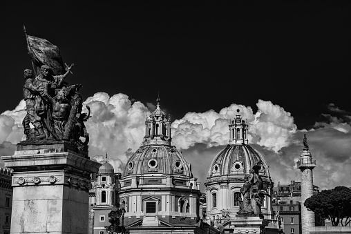 Twin Churches beautiful renaissance and baroque domes with ancient Trajan Column and clouds, seen from Altar of Nation Monument in the center of Rome