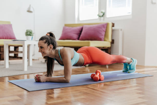 Young woman doing plank exercise in her home