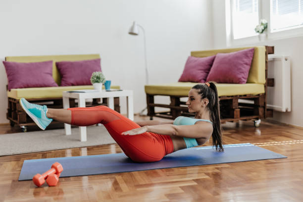 istock Young woman doing abs exercise in her living room 863991178