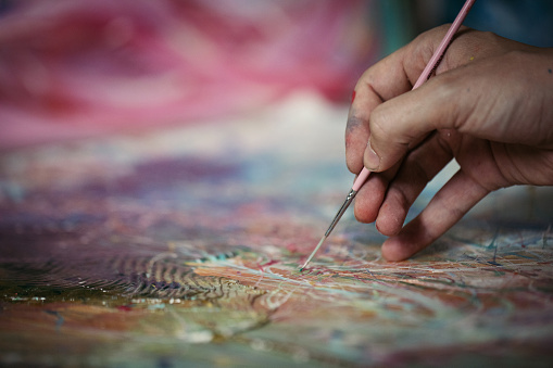One man, painting in his home studio, mixing the right colors, close up, part of.