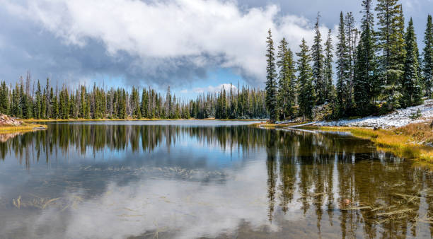 istock Storm clouds opening up over an alpine lake after a light autumn snow fall. 863993982