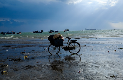 A lone bicycle stands on a beach in Vung Tau in the late afternoon