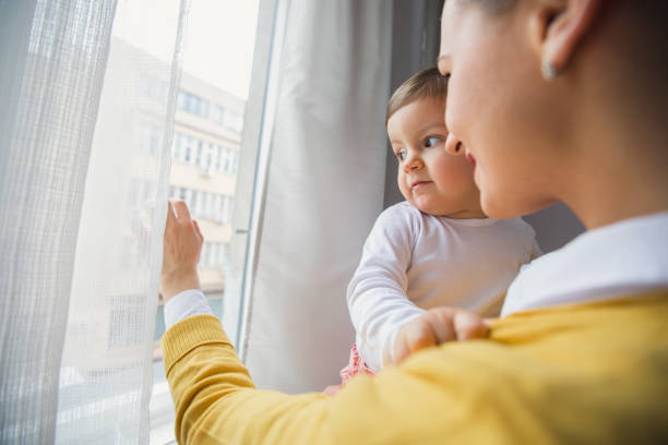 Mother and daughter looking through window