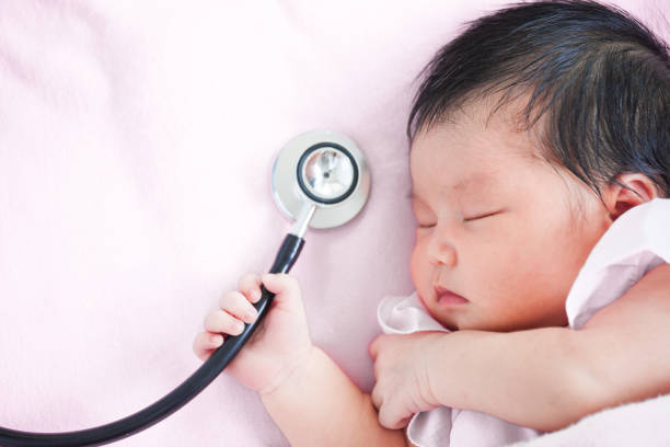 cute asian newborn baby girl sleeping and holding medical stethoscope in hand - doctor stethoscope nurse asian ethnicity imagens e fotografias de stock