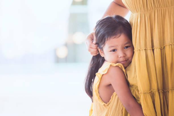 triste bambina asiatica che abbraccia la sua gamba madre in tono di colore vintage - pensive only baby girls baby girls baby foto e immagini stock