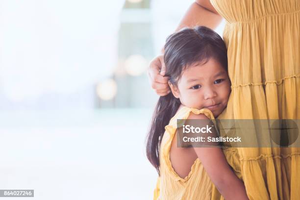 Sad Asian Child Girl Hugging Her Mother Leg In Vintage Color Tone Stock Photo - Download Image Now