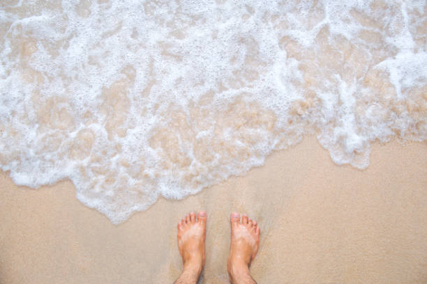 istock Sea wave movement with feet and sand. 864029688