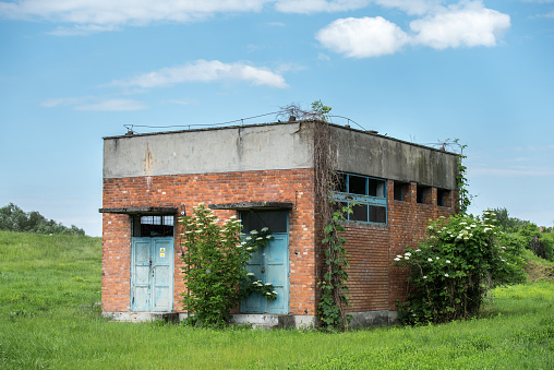 Old abandoned brick building on the field