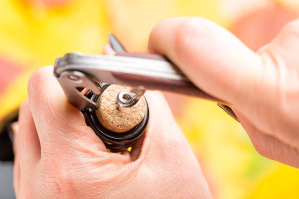 istock A woman's hand opens a bottle of white wine with a corkscrew.. Top view. 864037532