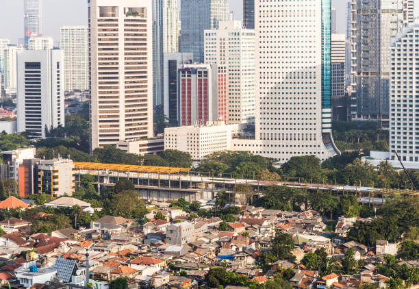 Aerial view of Jakarta financial district, Indonesia capital city in Asia Middle to low class residential district contrasts with the modern skyscrapers of the business district of Jakarta in Indonesia capital city. jakarta slums stock pictures, royalty-free photos & images