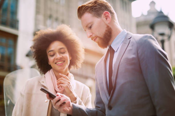 istock Happy business couple using smart phone outdoors 864049328