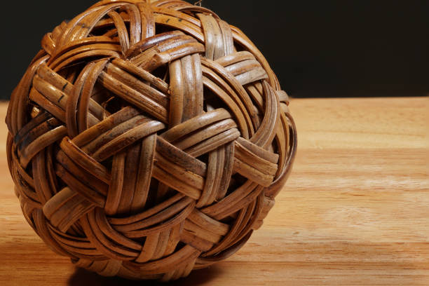 Rattan weaving ball wicker wear, sport ball famous in Asia Rattan weaving ball wicker wear, sport ball famous in Asia, on wooden table black background, HDR macro stacking photo bamboo twist stock pictures, royalty-free photos & images
