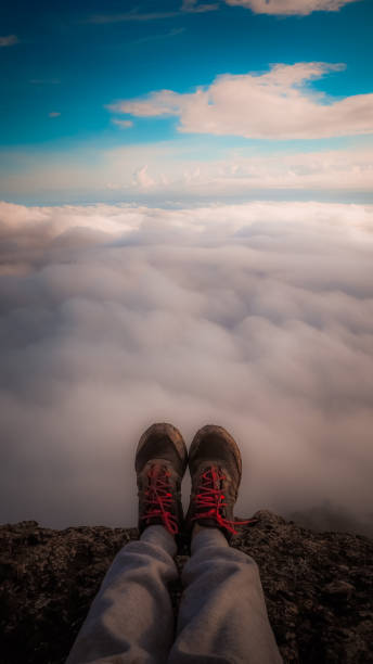 istock Happy woman sitting on a cliff side 864053538