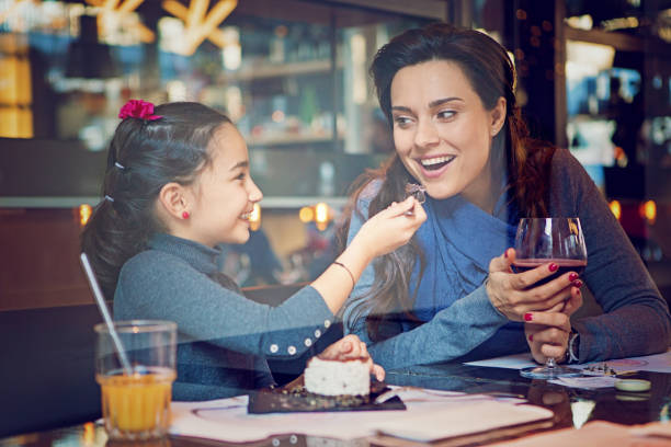 istock Daughter is feeding her mother with cake 864087418